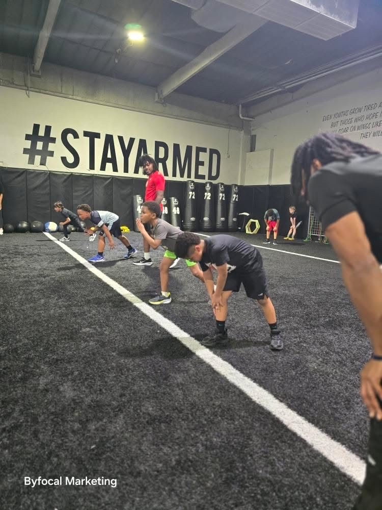 Young athletes training together beneath the Stay Armed wall