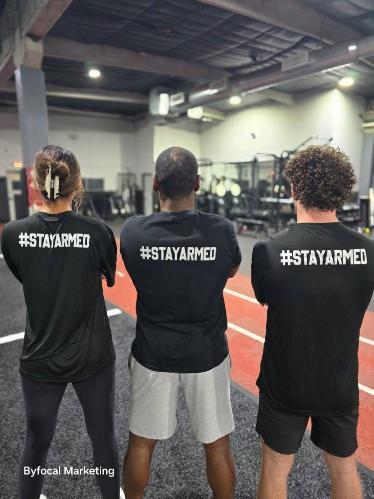 Armed Sports team wearing Stay Armed shirts inside the training facility