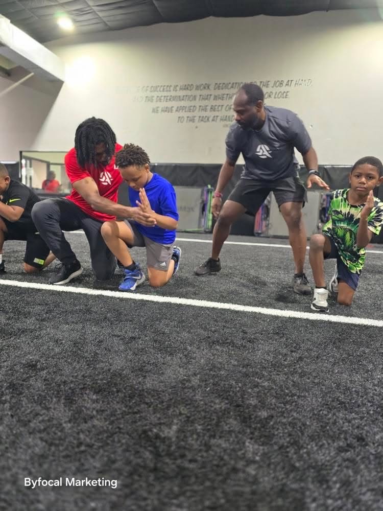 Armed Sports coaches teaching sprint mechanics to youth athletes