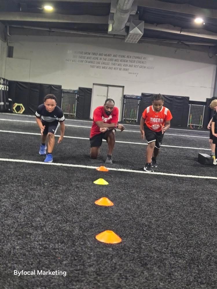 Young athletes practicing sprint starts with an Armed Sports coach